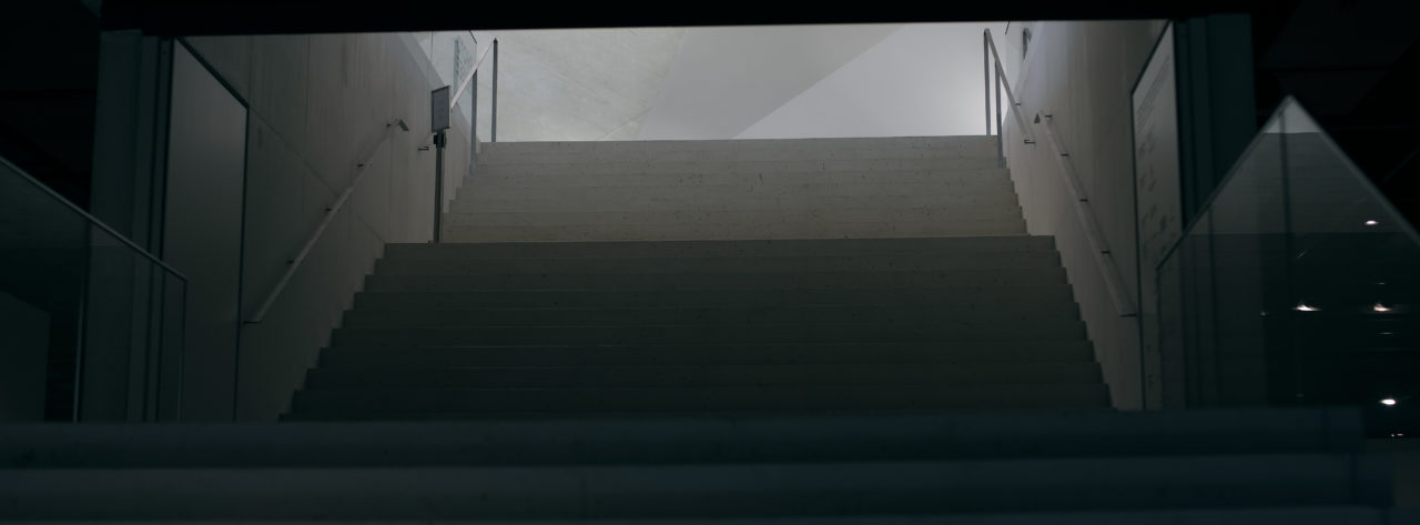Photographie des escaliers de l'intérieur du musée de l'Elysée avec de nombreuses variations de textures. Style cinématique avec des couleurs froides et motifs géométriques.
