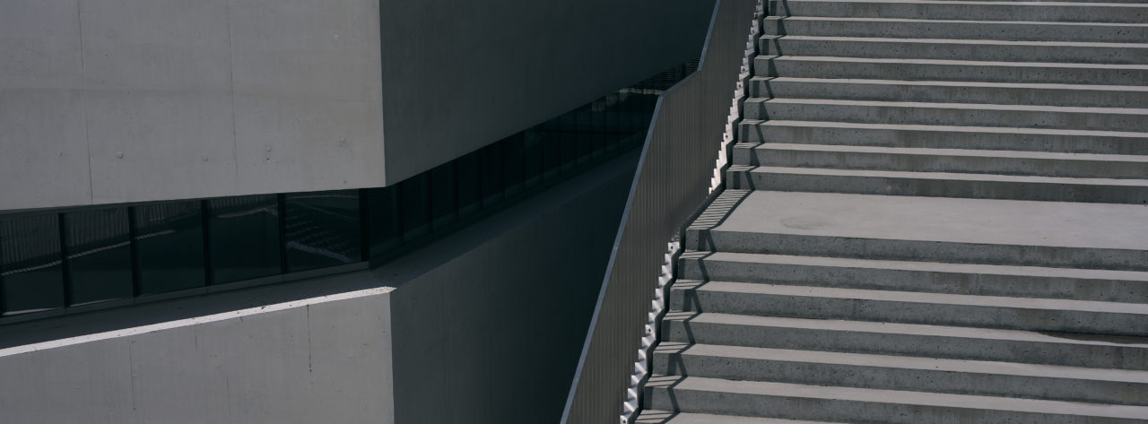 Photographie des escaliers et d'une partie du bâtiment du musée de l'Elysée à la plateforme 10 de Lausanne. Style cinématique avec des couleurs froides et motifs géométriques.